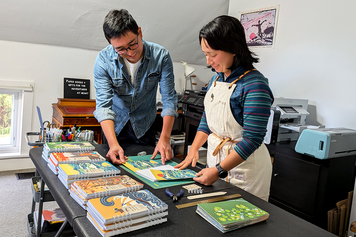 Dos artistas de Soijen con una mesa llena de cuadernos